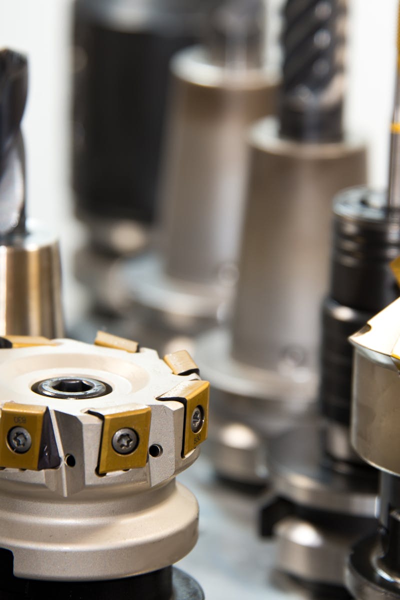 Detailed view of various metal drill bits and tools arranged in a workshop setting.