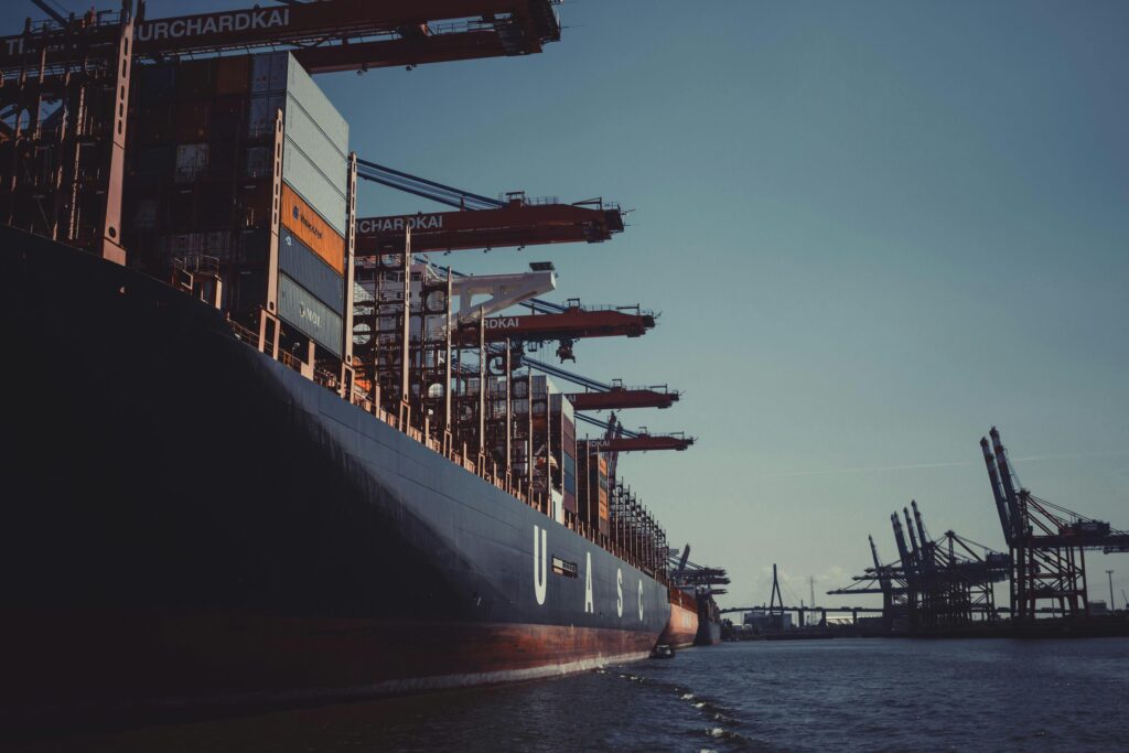 pexels photo 1095814 1095814 A large cargo ship docked at Hamburg Harbor, cranes loading containers under a clear sky.