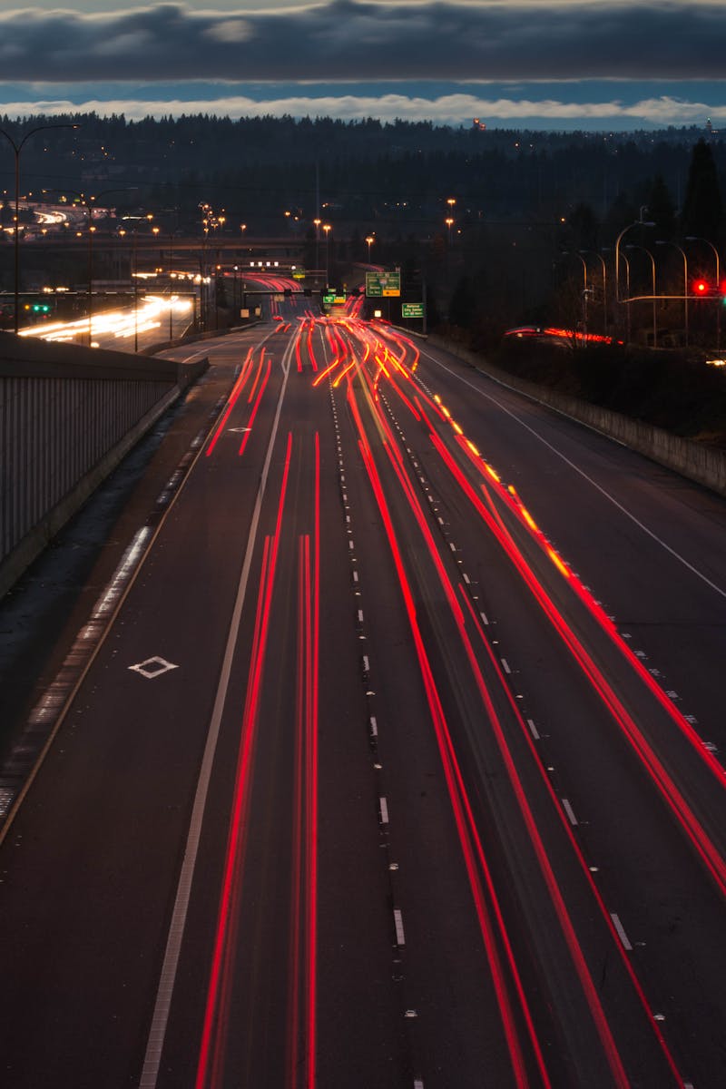 Dynamic night photo of a highway with red light trails showcasing fast-moving traffic.