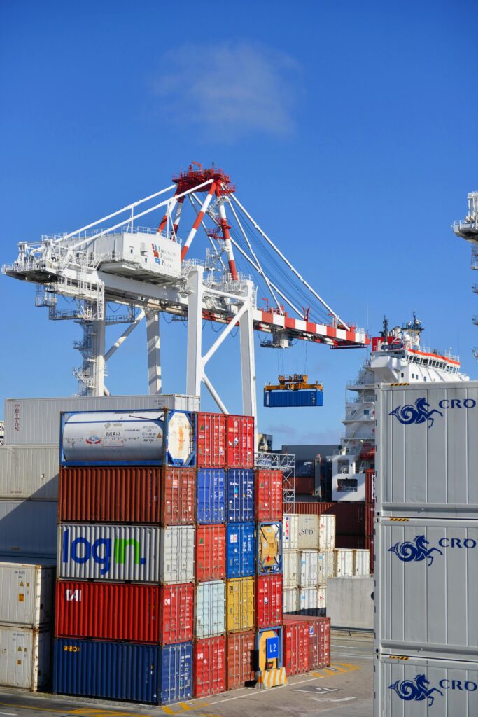 pexels photo 1624695 1624695 2 Colorful shipping containers stacked in a busy port with cranes overhead.
