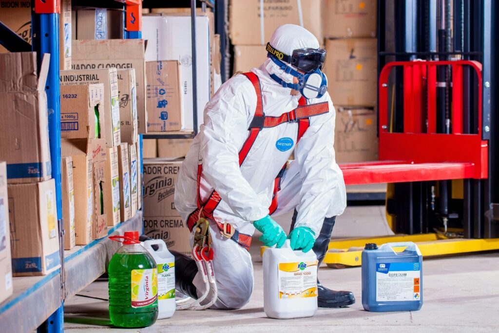 pexels photo 209230 209230 Industrial worker in protective gear handling chemicals in a warehouse environment.